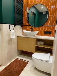 a bathroom with a toilet and a sink and a mirror at ZIELONE DRZWI Hajnówka in Hajnówka