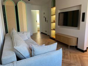 a living room with a couch and a flat screen tv at ZIELONE DRZWI Hajnówka in Hajnówka