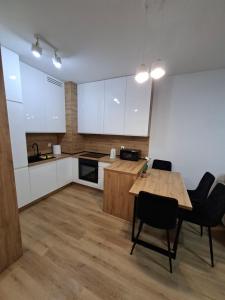 a kitchen with a table and chairs in a room at Apartament Karbowo in Brodnica
