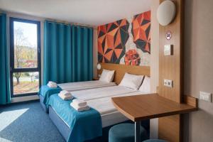 a bedroom with a bed and a table and a window at WESTGATE Hotel - FREE PARKING in Veliko Tŭrnovo +19 photos