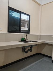 an empty room with a sink and a window at Zara Residence Room1 in Lagao