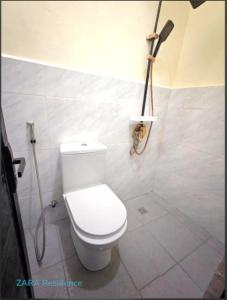 a bathroom with a toilet and a shower at Zara Residence Room1 in Lagao