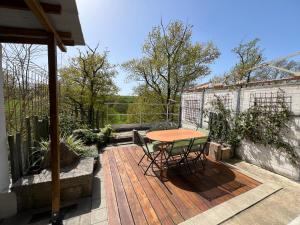 a wooden deck with a table and chairs on it at Les Iris - Maison chaleureuse in Montigné-sur-Moine