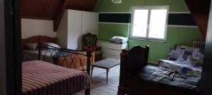 a bedroom with green walls and two beds and a window at Le Clos Joli 15 in Molompize