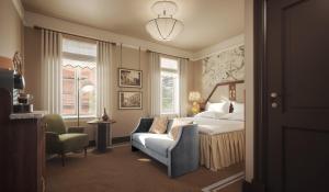 a bedroom with a bed and a couch and a chair at Savoy 1918, a member of Small Luxury Hotels of The World in Oslo +173 photos