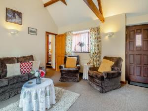 a living room with couches and chairs and a table at Pear Tree Cottage in Banham