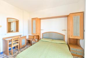 a bedroom with a bed and a desk and a mirror at Hotel Tramonto d'oro Terme Casthotels in Forio d'Ischia +53 photos
