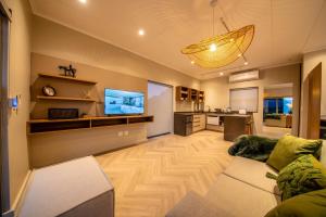a living room with a couch and a flat screen tv at LEO Sky Farm Cottages in Simondium