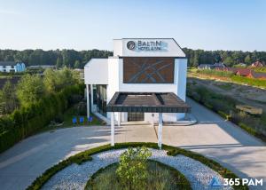a building with a sign on the side of it at 365PAM - Apartament nr 32 w Mielenku - BASEN KRYTY, ANIMACJE DLA DZIECI, JACUZZI, SAUNA,PLAC ZABAW W CENIE in Mielenko