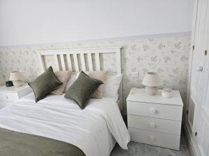a bedroom with a white bed and two night stands at Solo or Couple , Solo o Pareja in Seville