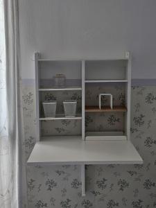 a white shelf in a room with wallpaper at Solo or Couple , Solo o Pareja in Seville +15 photos