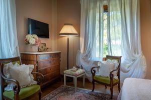 a bedroom with two chairs and a dresser and a window at Villa Sestilia Guest House in Montaione +46 photos
