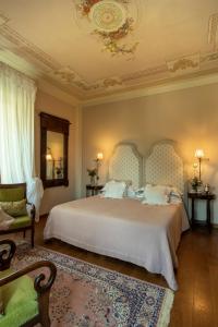 a bedroom with a large bed and a chair at Villa Sestilia Guest House in Montaione