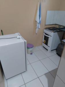 a small kitchen with a stove and a refrigerator at kitinete - SALVATERRA GUARAMIRANGA in Guaramiranga