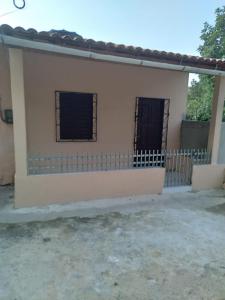 a small house with two windows and a fence at kitinete - SALVATERRA GUARAMIRANGA in Guaramiranga