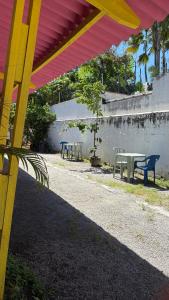 a group of tables and chairs under a red and yellow roof at Pousada Suítes Sete Mares in Guarujá