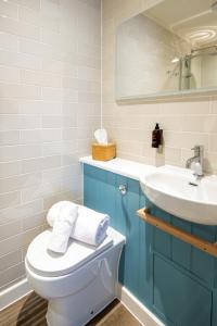 a bathroom with a toilet and a sink at The Bell Hotel, Saxmundham in Saxmundham +55 photos