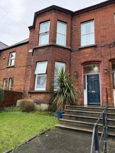 a brick house with a blue door and stairs at ABC House in Dublin