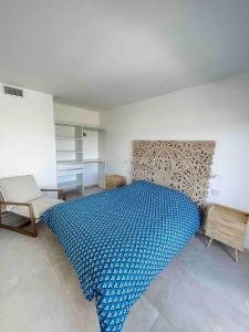 a bedroom with a blue bed and a chair at Rare T2 New, Waterfront in Porticcio