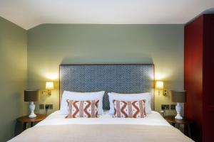a bedroom with a large bed with two pillows at The Bell Hotel, Saxmundham in Saxmundham