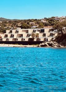 a large building on a beach with blue water at Rare T2 New, Waterfront in Porticcio