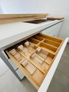 an open drawer in a kitchen with wooden drawers at Rare T2 New, Waterfront in Porticcio +14 photos