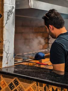 a man is cooking food in an oven at ULORA Luxury Camp in Wadi Rum