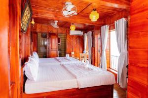 a bedroom with a large bed in a wooden room at Bungalow Hải Yến in Ly Son