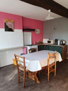 a kitchen with a table and chairs in a room at Maisonnette La Bienvenue in Trainel