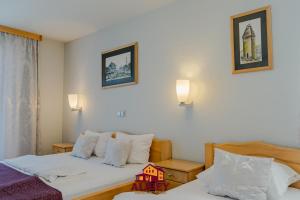 a hotel room with two beds and two lamps at Motel Alibey in Bugojno