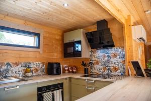 a kitchen with wooden walls and a wooden ceiling at Gîte de charme Ò Chalet in Camors