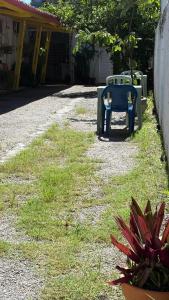 a blue chair sitting on the grass in a yard at Pousada Suítes Sete Mares in Guarujá