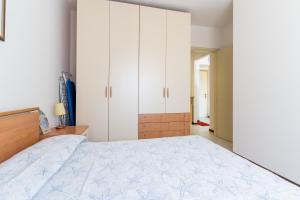 a bedroom with a large bed and white cabinets at Residence Selenis Apartments in Caorle +37 photos