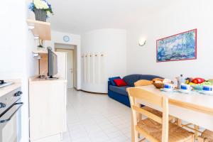 a kitchen and living room with a blue couch at Residence Selenis Apartments in Caorle