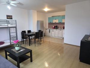 a living room with a dining table and a kitchen at Perla View Apartment in Primorsko