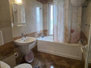 a bathroom with a tub and a sink and a toilet at Perla View Apartment in Primorsko +18 photos
