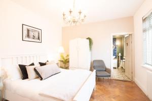 a white bedroom with a white bed and a chair at Northern Hideaways, Sunnyside, Otterburn in Otterburn