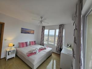a small bedroom with a bed and a window at Perla View Apartment in Primorsko