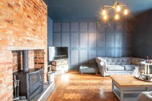 a living room with a couch and a fireplace at Northern Hideaways, Sunnyside, Otterburn in Otterburn