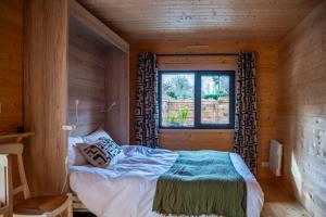 a bedroom with a bed in a wooden room at Gîte de charme Ò Chalet in Camors