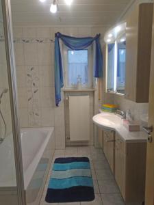 a bathroom with a tub and a sink and a bath tub at Im Haus am Ries in Ehingen am Ries +27 photos