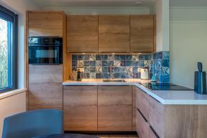 a kitchen with wooden cabinets and a sink at Zilte Bries in De Koog