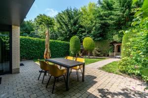 a patio with a table and chairs and an umbrella at Zilte Bries in De Koog