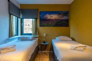 two beds in a room with a window at Zilte Bries in De Koog