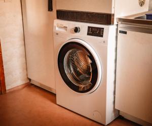 a white washing machine sitting in a kitchen at Gårdshuset på Wrågården in Falköping