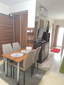 a dining room with a table and chairs and a television at Apartmán Mery in Podhájska