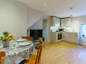 a living room with a dining table and a kitchen at The Cottage-Uk32854 in Neath