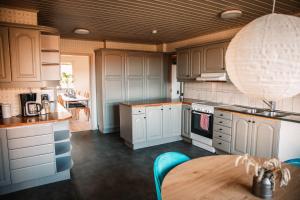 a kitchen with white cabinets and a wooden table at Gårdshuset på Wrågården in Falköping