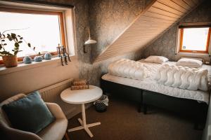 a bedroom with a bed and a table and a chair at Gårdshuset på Wrågården in Falköping