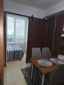 a dining room with a table and a bed and a window at Apartmán Mery in Podhájska +8 photos